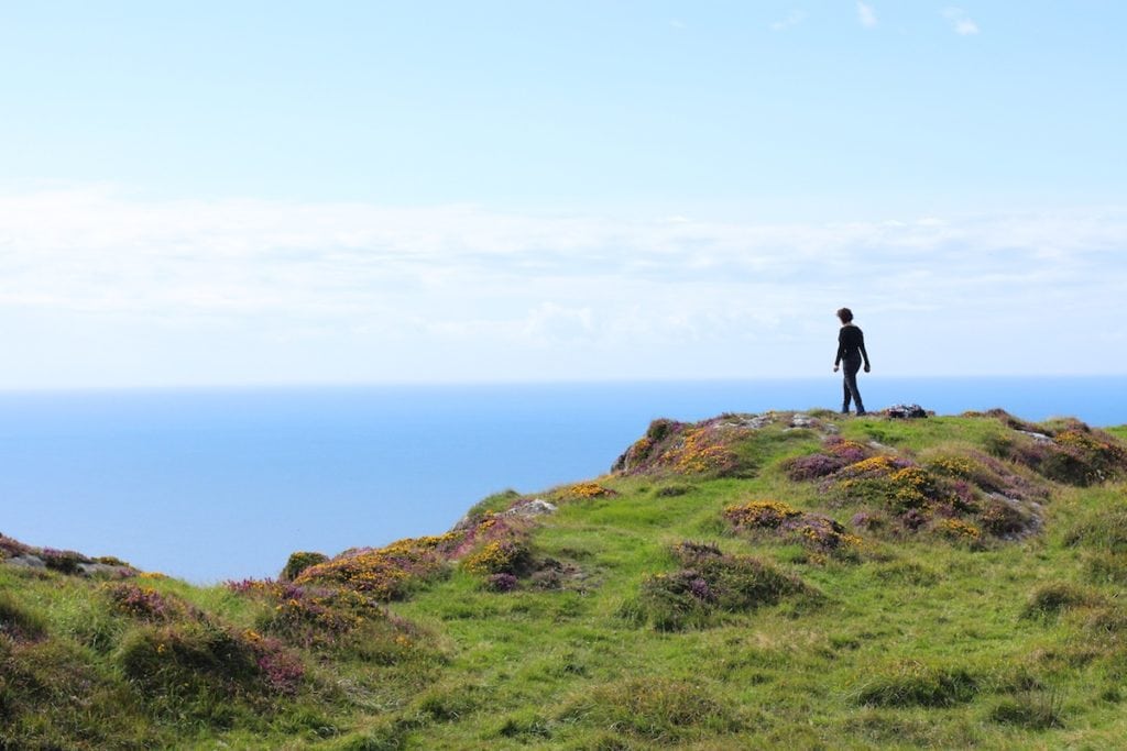 A picture of a woman on a beautiful Irish landscape near the sea